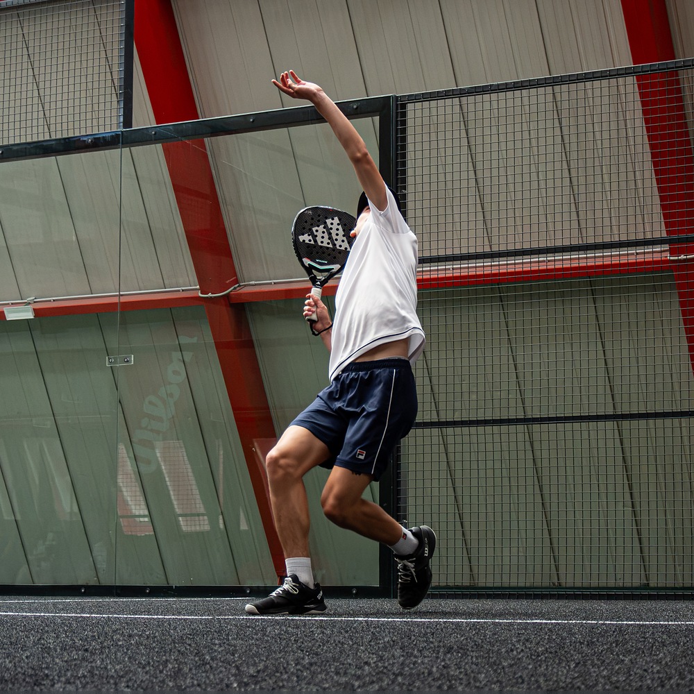 Bandeja eseguita da un giovane atleta durante un allenamento di padel agonistico a Treviso