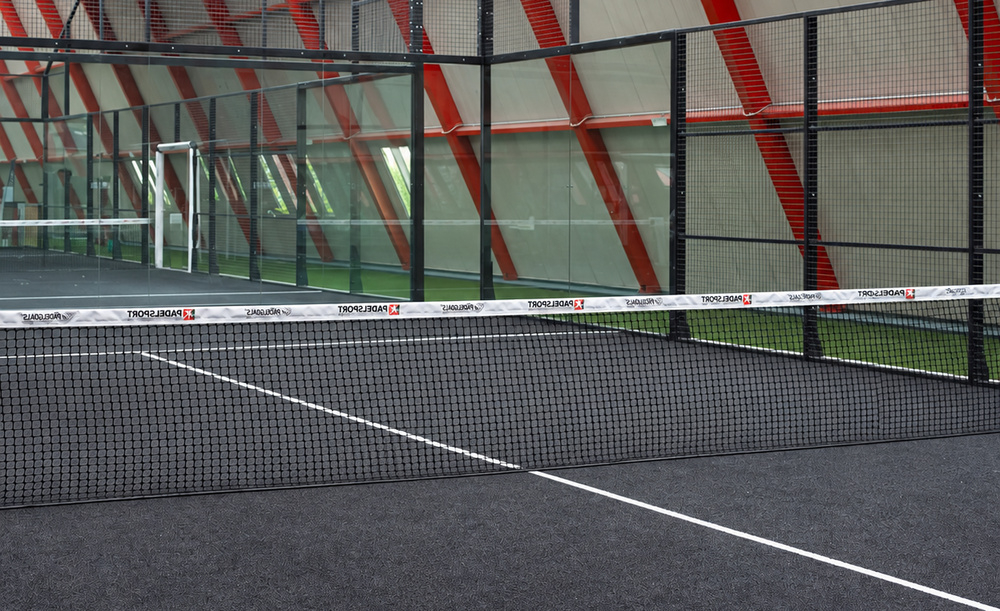 Campo da padel coperto dell’Adriano Panatta Racquet Club di Treviso, con rete e pareti in vetro.