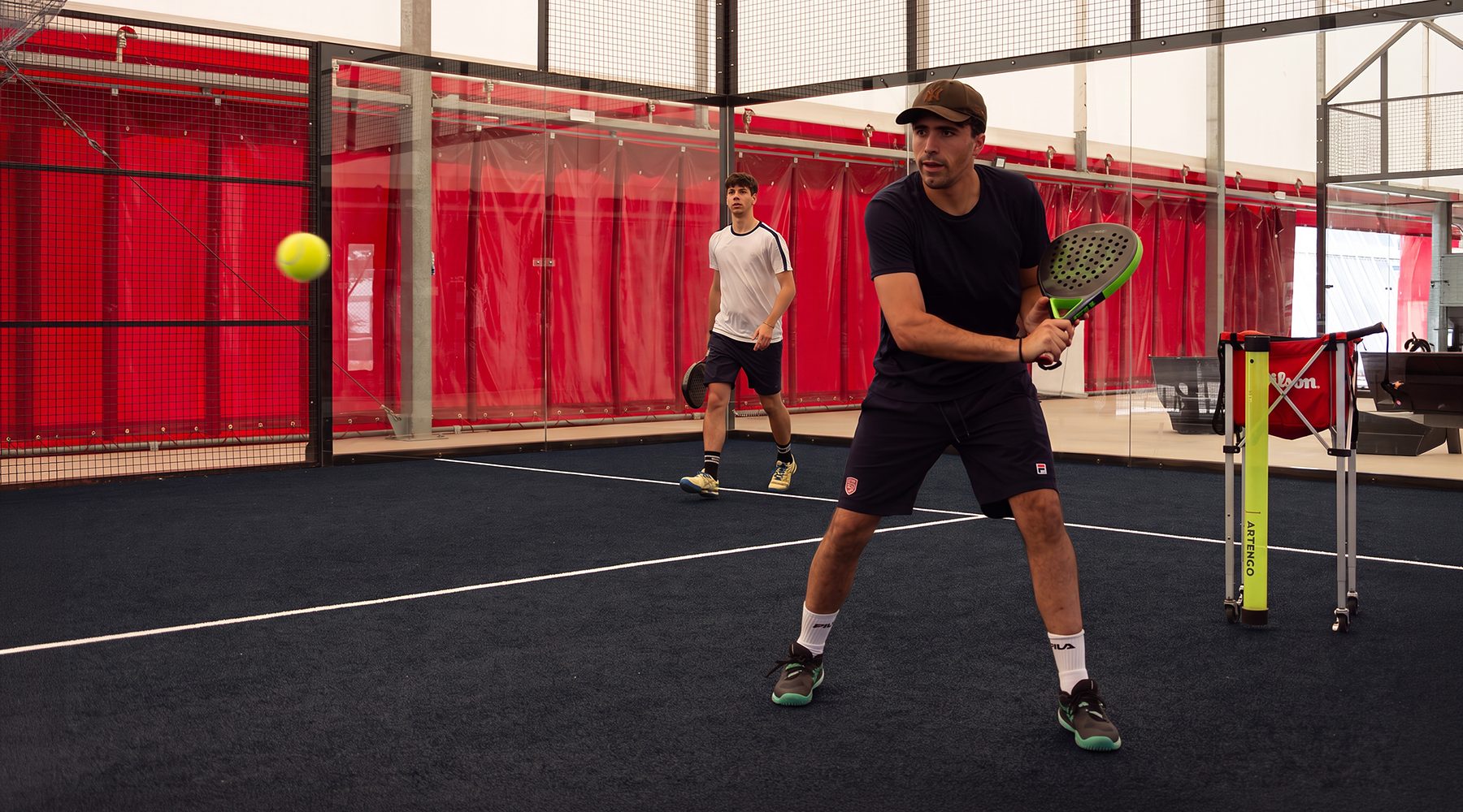 Coppia di giocatori durante una partita di padel in doppio sul campo indoor a Treviso