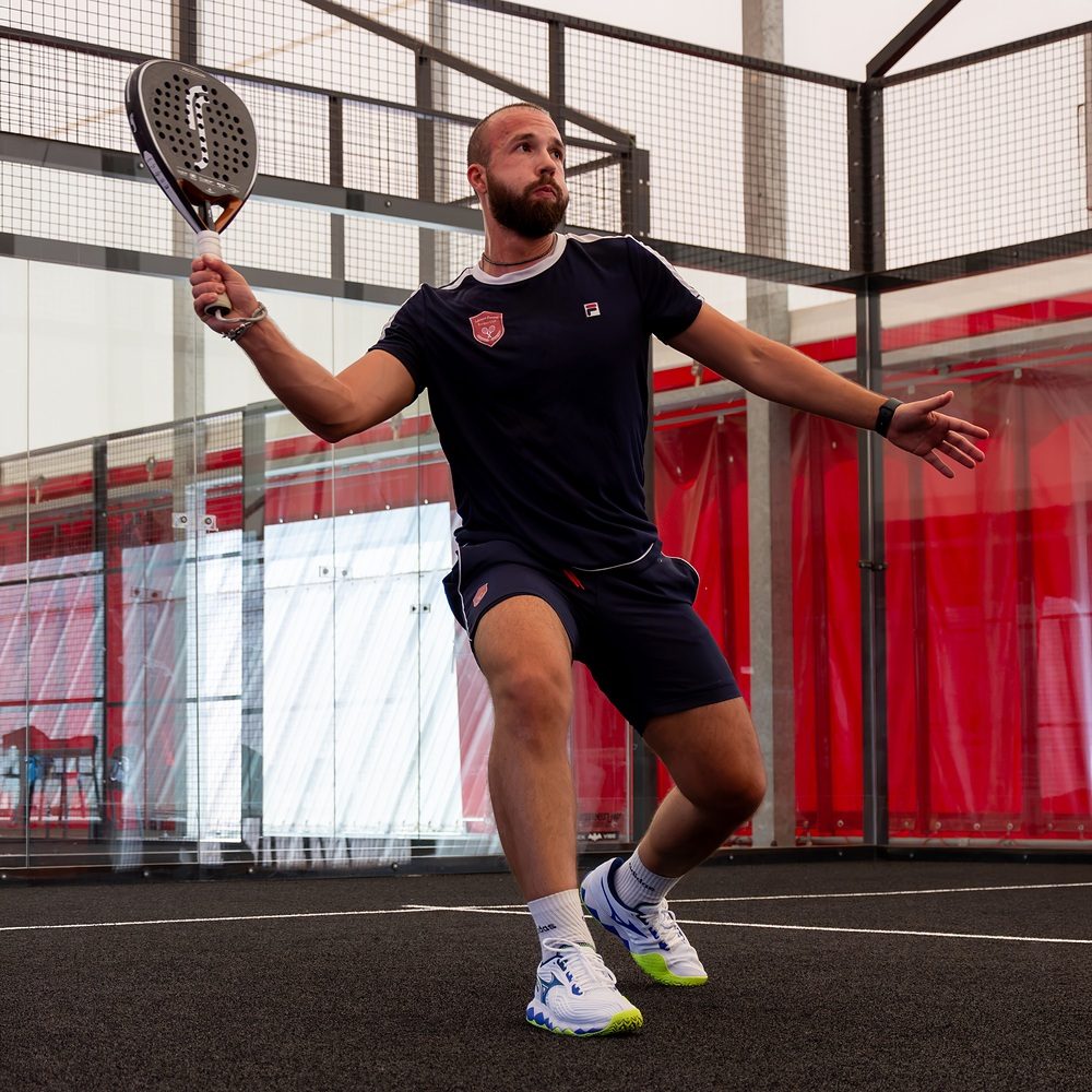 Volée alta giocata a rete durante una partita di padel a Treviso